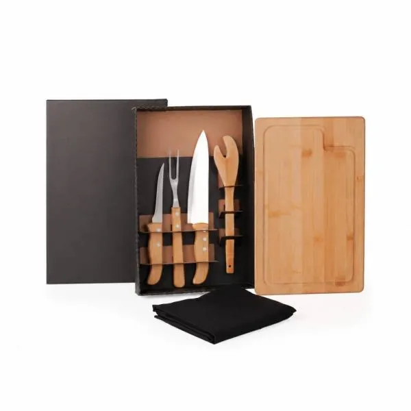 Kit para Churrasco. Composto por tábua e pegador de 30 cm em Bambu; faca 8, faca 5 para desossar e garfo trinchante em Madeira/Inox. Acompanha também avental com bolso em Brim preto. Como cortesia, na faca 8 fazemos uma gravação com os cortes do boi.