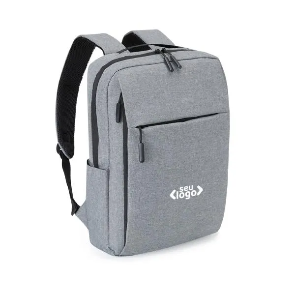 Mochila cinza em poliéster 300D. Conta com compartimento principal com espaço para notebook e fecho em velcro para melhor fixação e segurança do notebook, compartimento médio com zíper vertical e um compartimento menor com zíper horizontal; além dos compartimentos com zíper, contém também um bolso externo lateral. Conta também com alças almofadadas e ajustáveis para as costas e alça de mão.